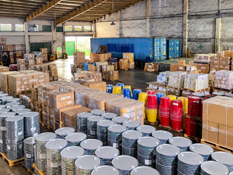 Consolidated cargo pallets and drums staged in a warehouse